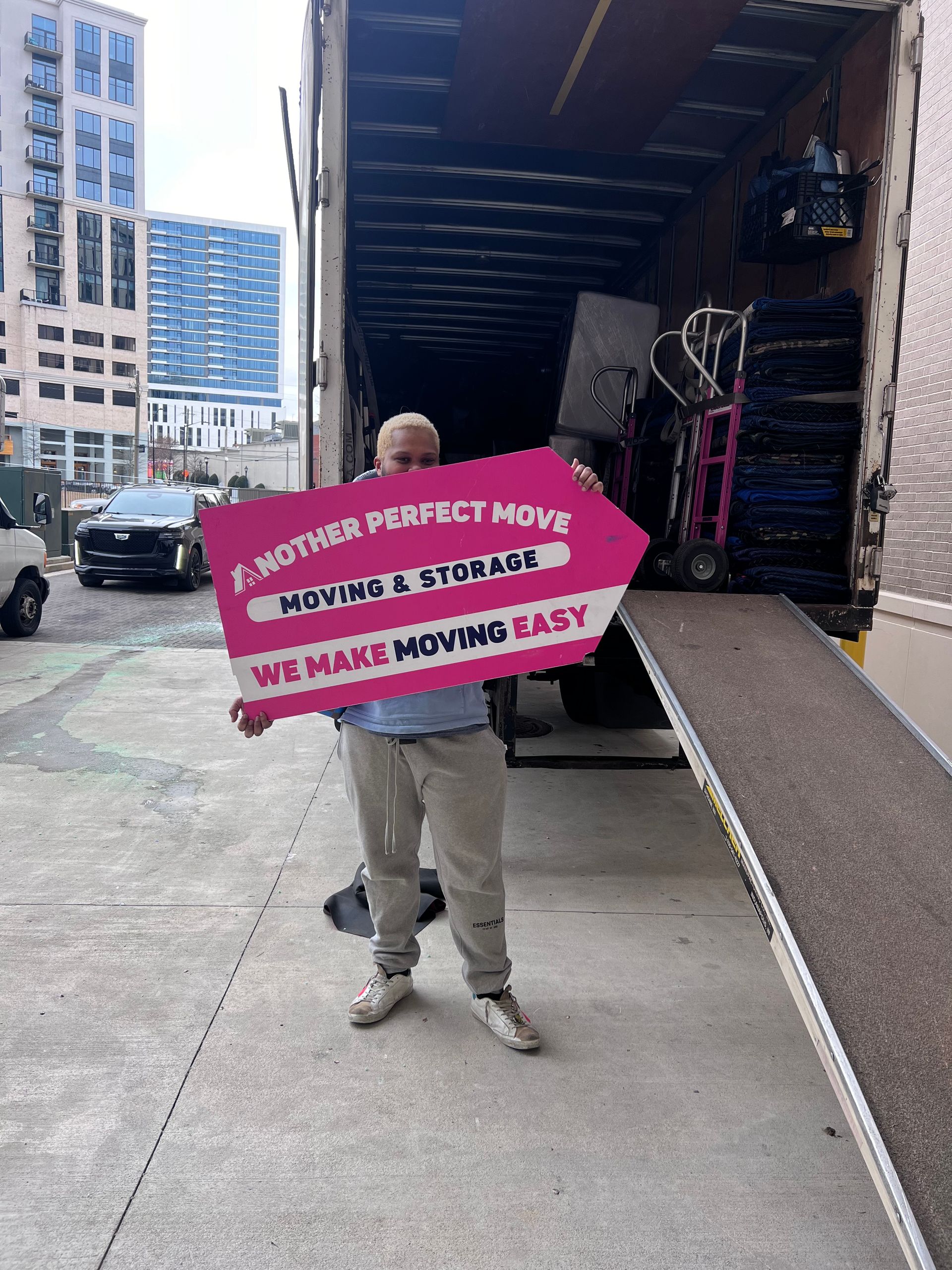 Customer holding the We Make Moving Easy sign by the truck